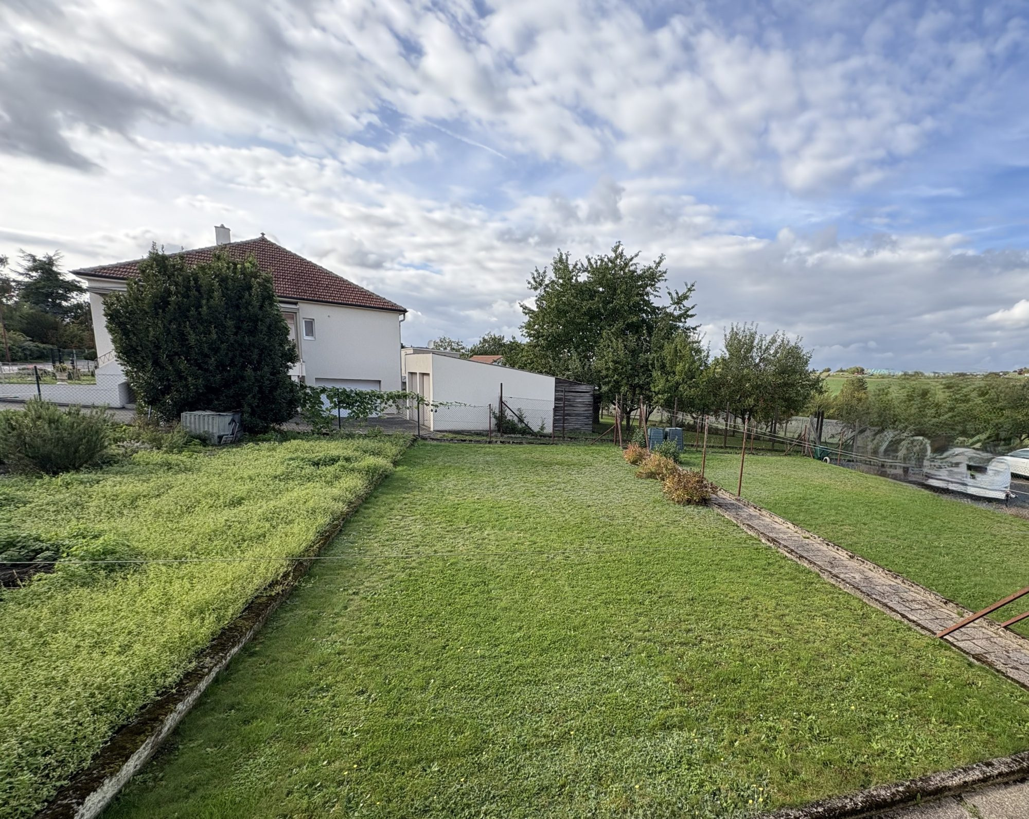 Maison mitoyenne avec jardin et garage.